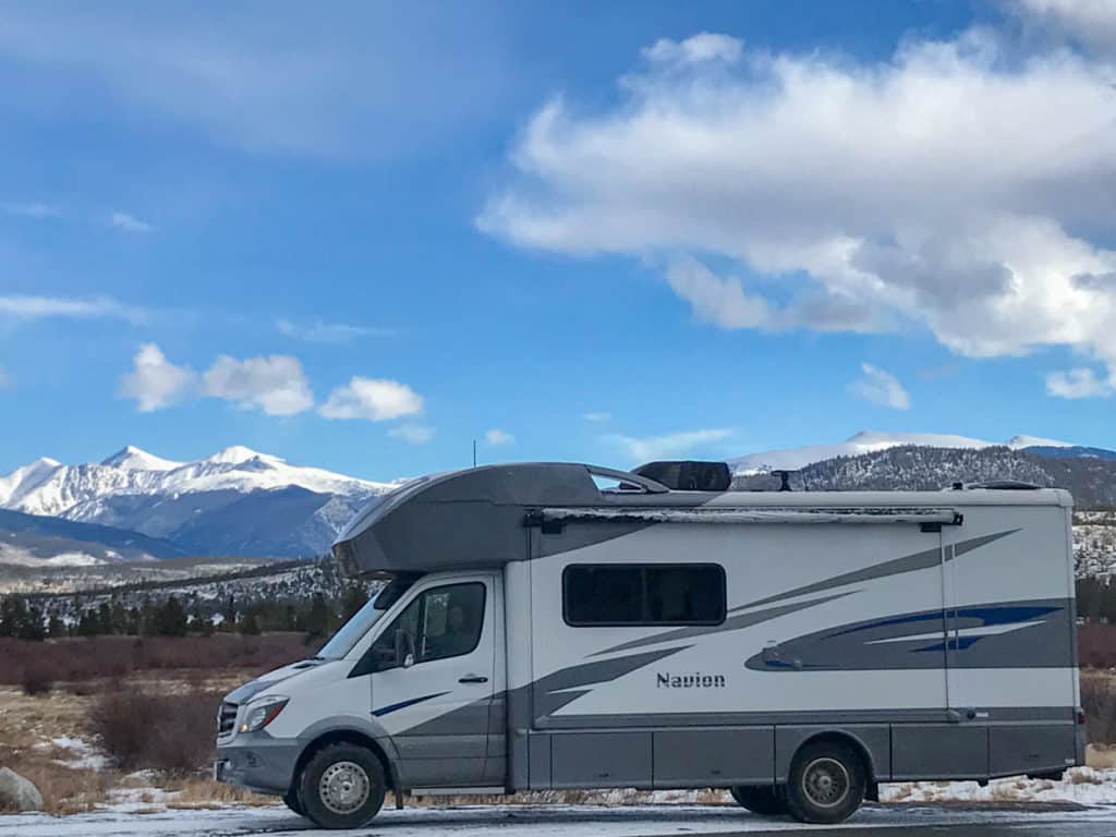 RV parked in front of snow capped mountains in Colorado in the winter