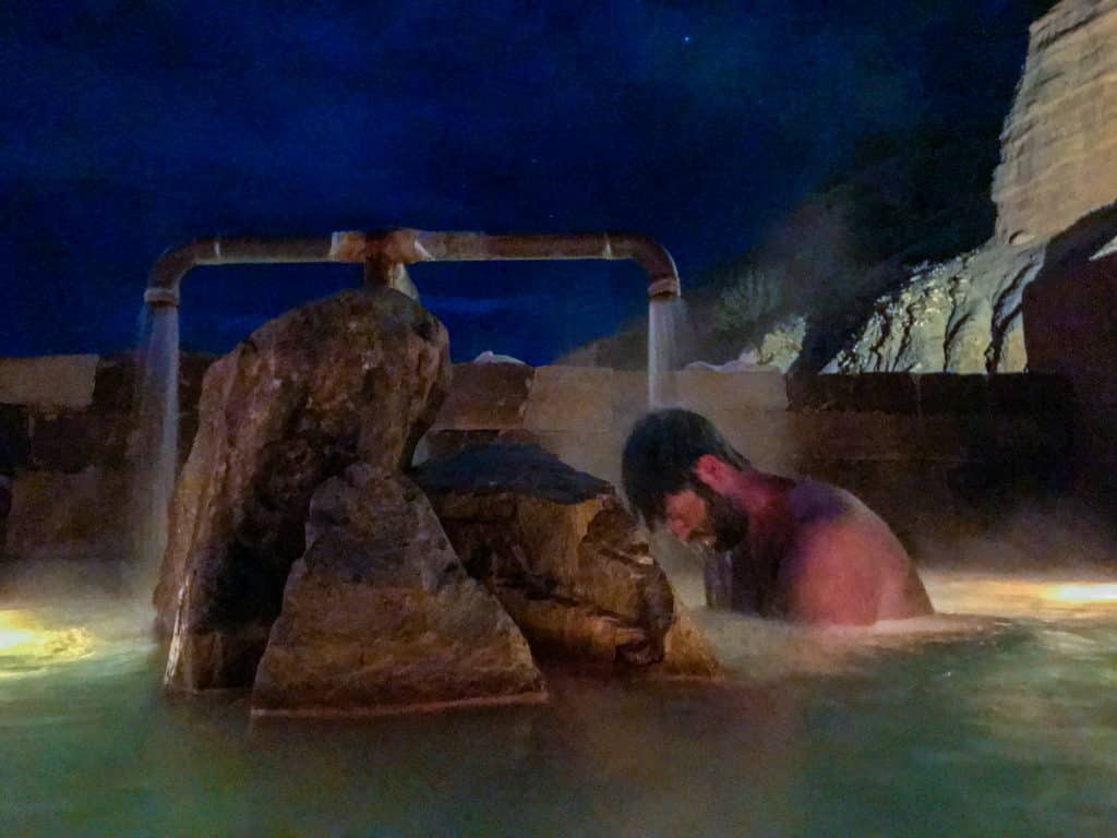 man soaking in mineral springs at ojo caliente new mexico under the stars