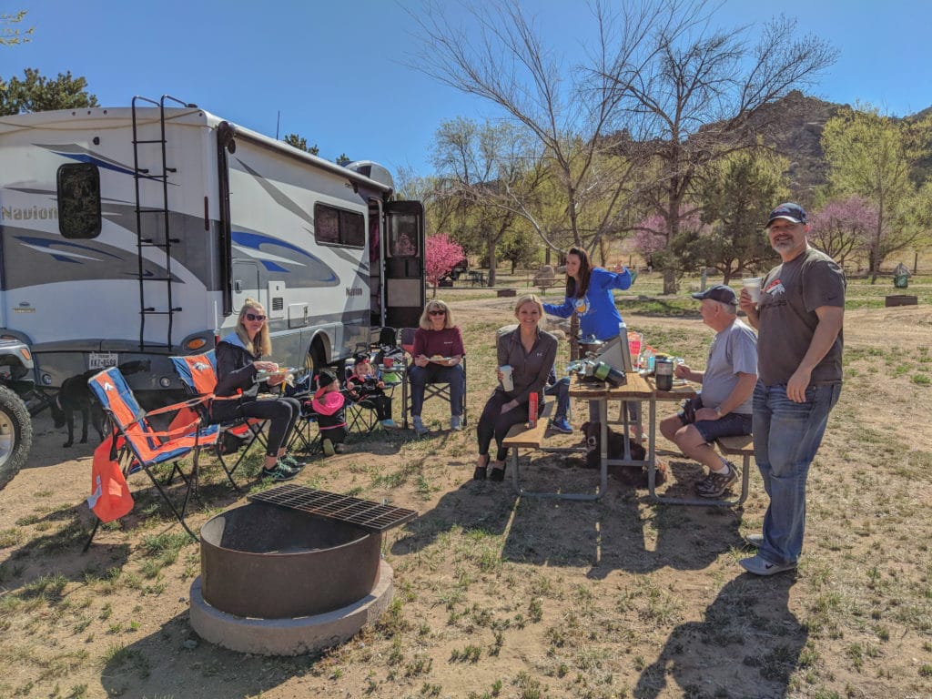 family camping and eating breakfast at campsite