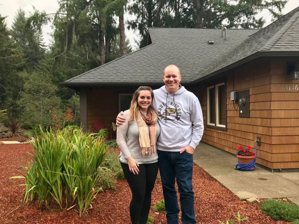 couple standing in front of house