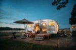 camper set up at night man sitting outside
