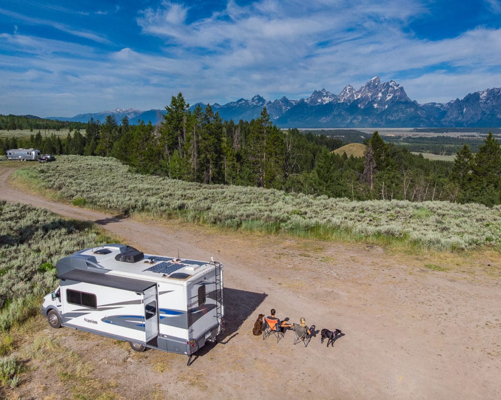 Couple sitting in camping chairs with motorhome parked near Grand Teton National Park