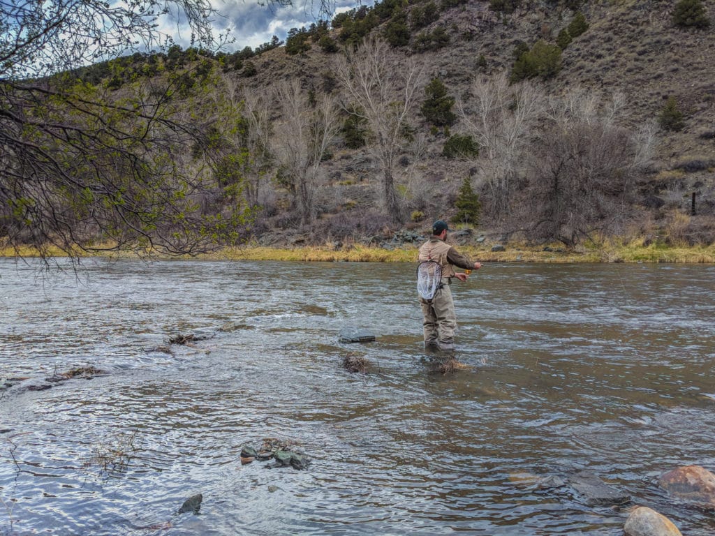 man fly fishing in a river