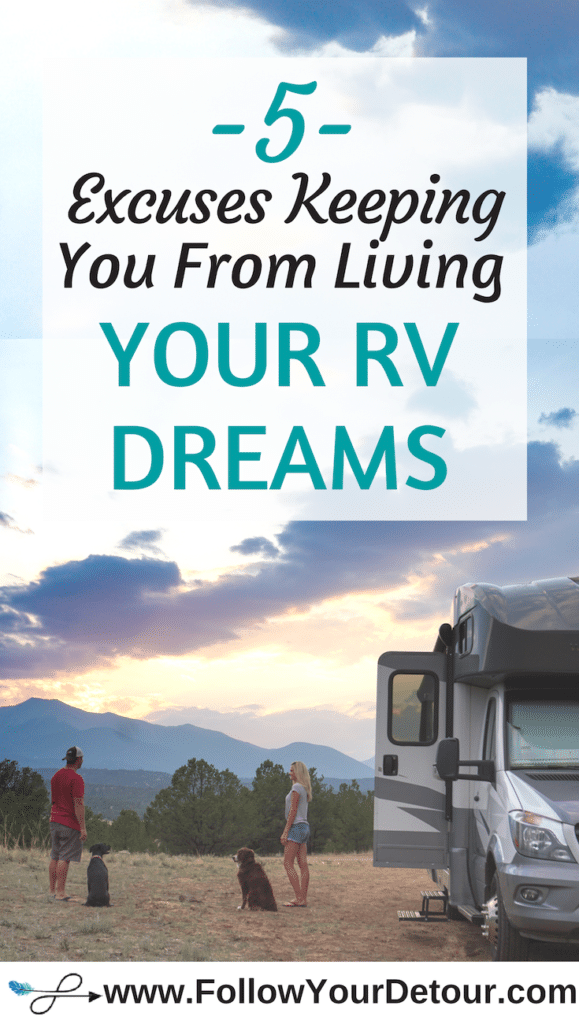 couple standing outside of motorhome with sunset and mountain views and two dogs