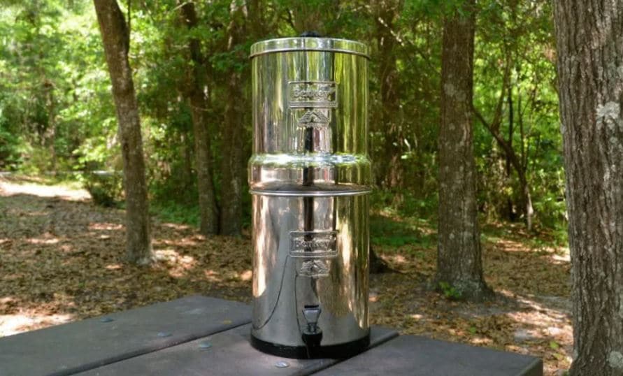 berkey water filter system on picnic table in woods