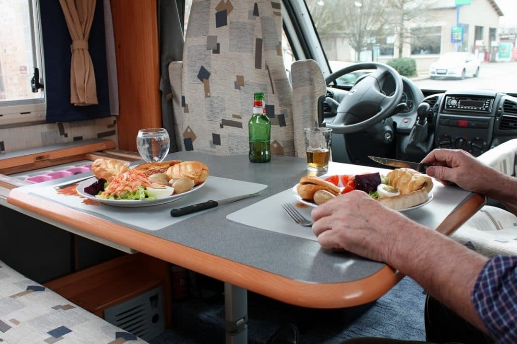 Campers eating a meal inside an RV