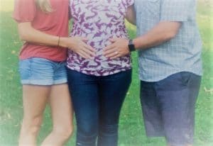 Adoptive couple putting hands on birth mom's pregnant belly