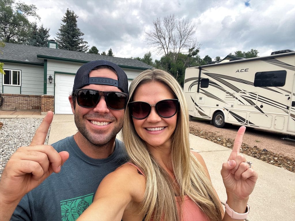 Couple pointing at house and RV in driveway