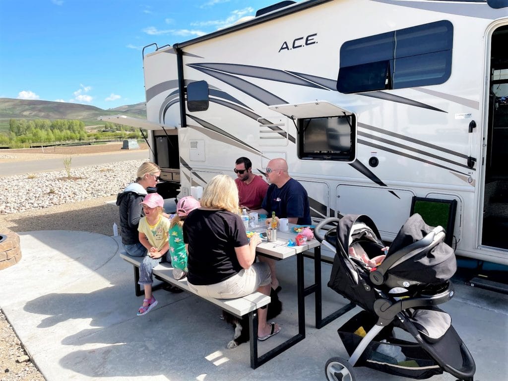 Family having breakfast outside of RV in campground