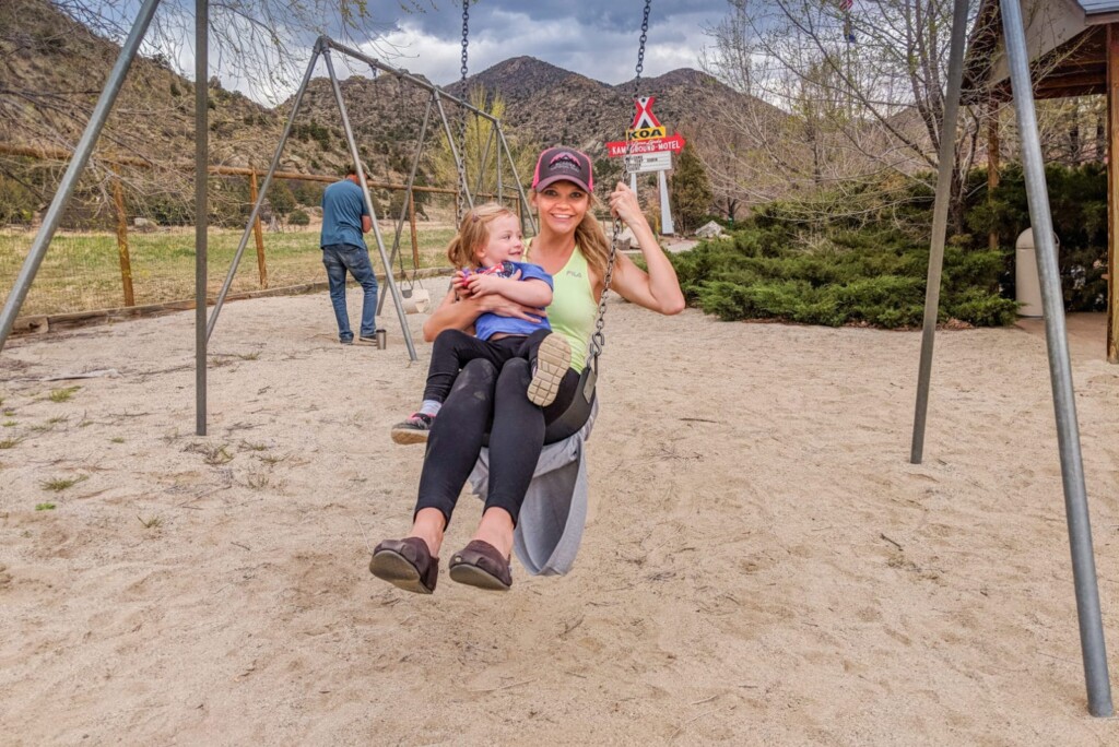 Lindsay swinging with our niece woman and toddler swinging at playground