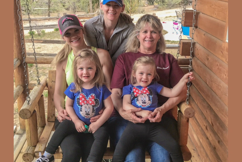 Lindsay swinging on the cabin porch swing with her mom, sisters, and adorable twin nieces. family swinging on cabin porch swing at KOA campground